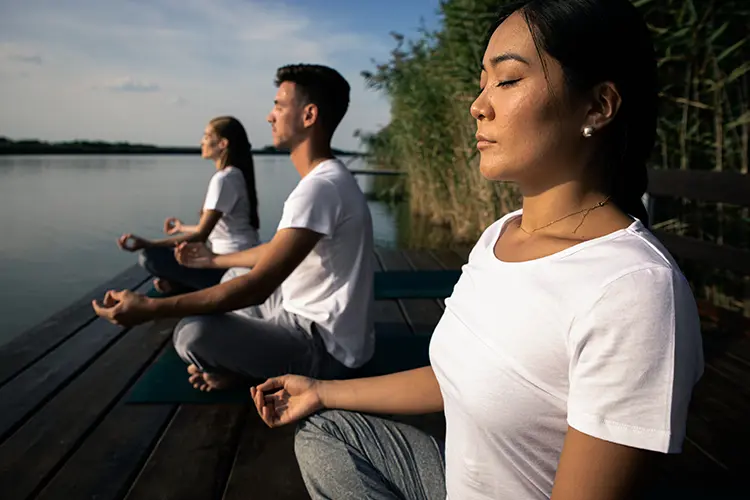 A person wiping sweat during a heated yoga class