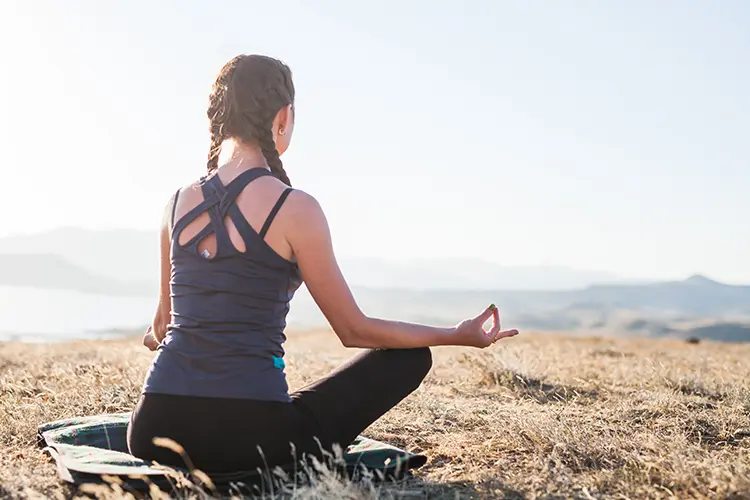 A person sitting calmly with eyes closed during a meditation session