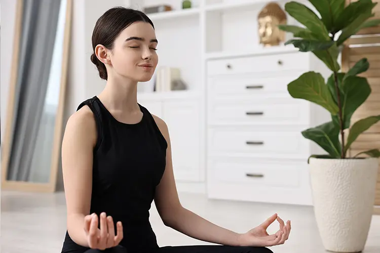 A teenager taking a calm break from studying, sitting quietly with eyes closed